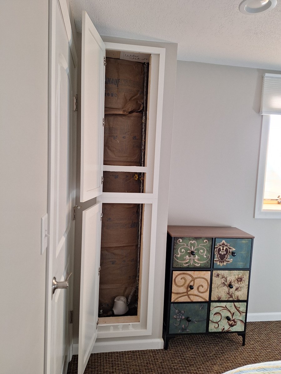 water pipes are hidden behind this cabinet in the bedroom. This space is not for your use. It is part of the guts of the house.