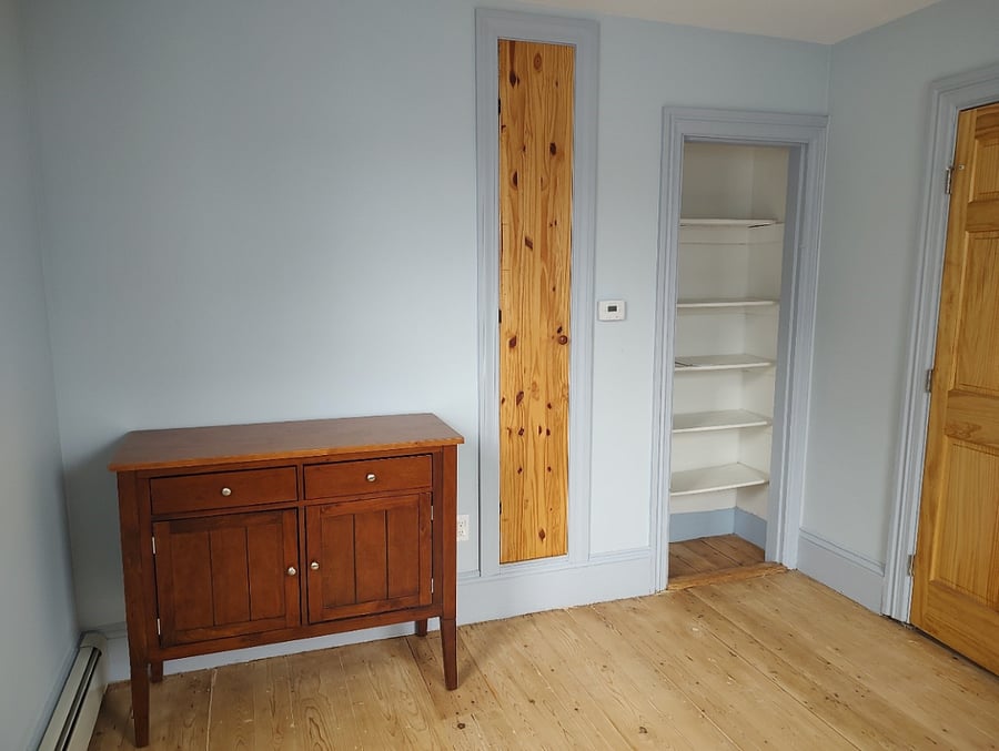 Bedroom on second floor. Has queen sized bed, bedside table and this wooden cabinet. Two small closets. 