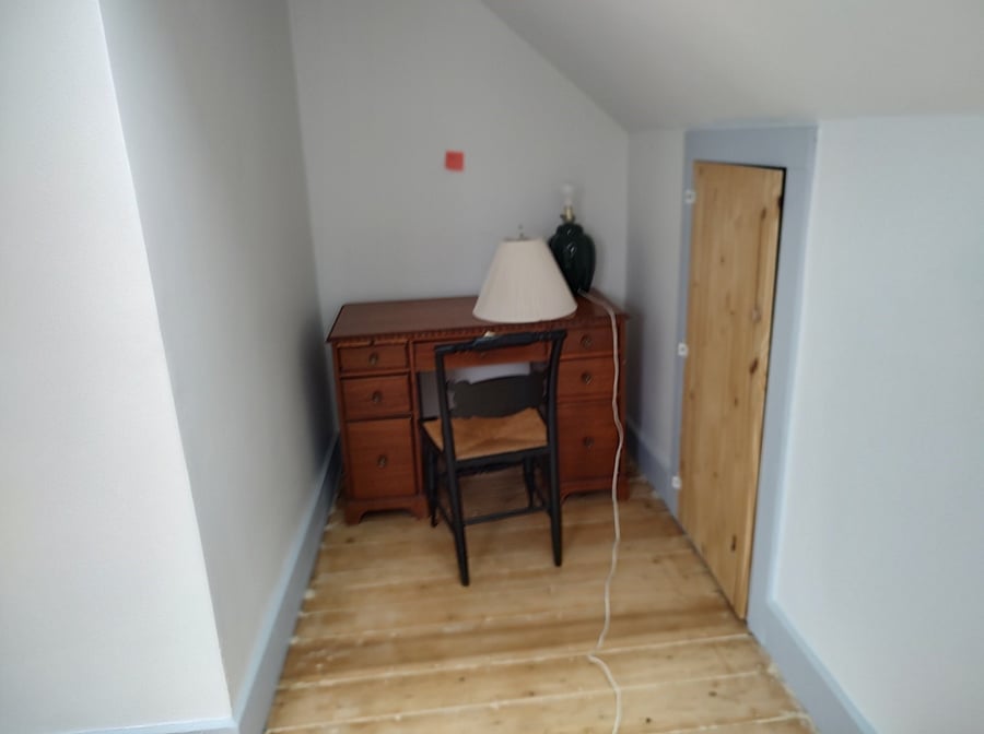 Third floor bedroom has this small alcove where there is a desk, lamp and a chair.