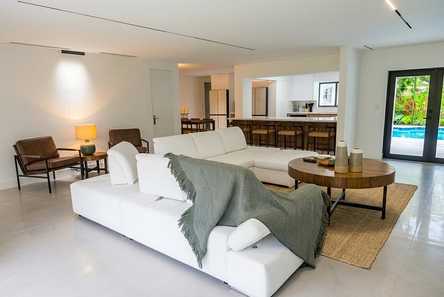 The living room offers a bright and spacious setting with comfortable seating, a large TV, and beautiful natural light, creating an inviting space to relax, watch movies, and enjoy time together during your Coral Springs stay.