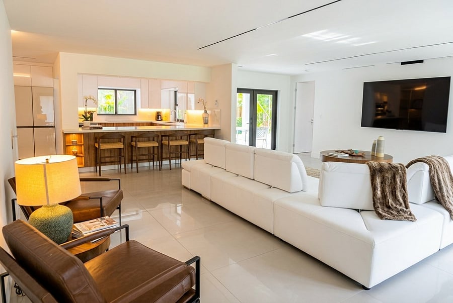 The open living area offers comfortable seating, a large TV, and a seamless connection to the kitchen and pool area, creating the perfect space to relax, gather, and enjoy your Coral Springs stay.