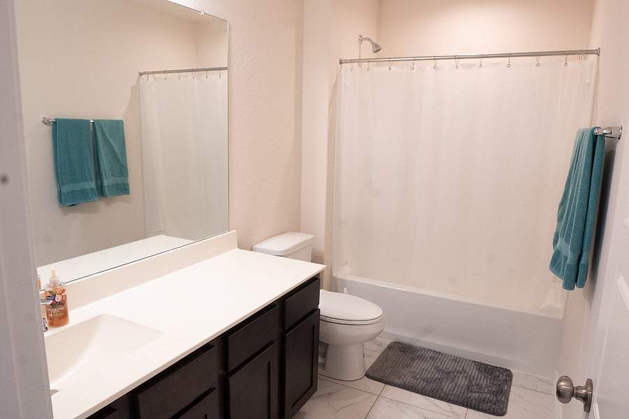 2nd Full Bathroom Featuring a Large Mirror, Extended Vanity, and Convenient Shower/Tub Combo