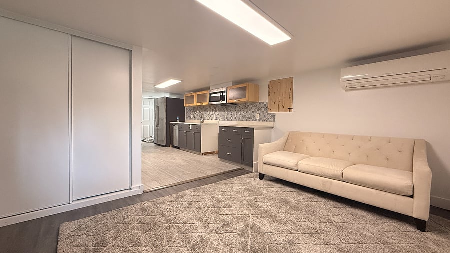 Living room and closet for pantry or linen. Partial view of kitchen