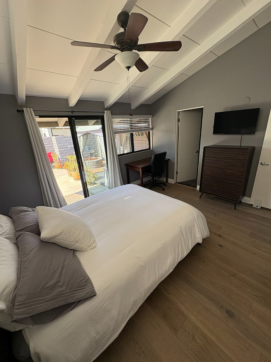 The primary bedroom offers everything you need: Wall-mounted TV, dresser, blackout curtains and a pool just steps away.