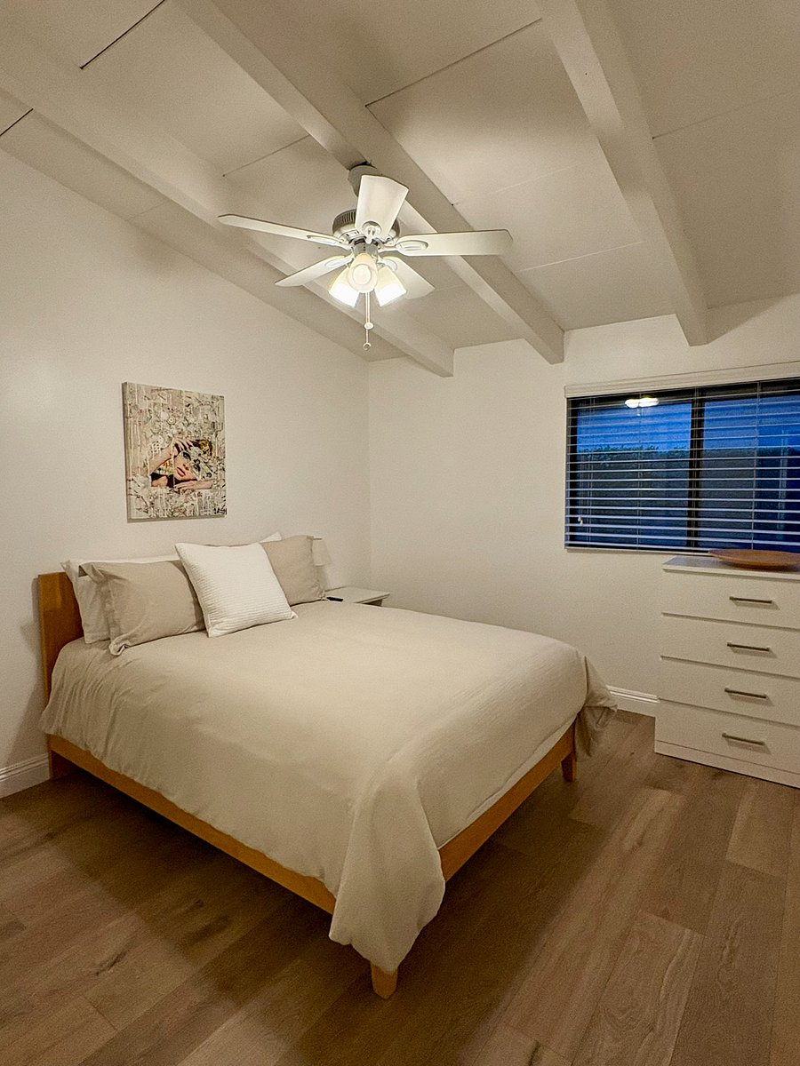 Quiet and comfortable, the second bedroom with beamed ceilings, brand new floors and plenty of drawer space make this guest room feel like your home away from home.