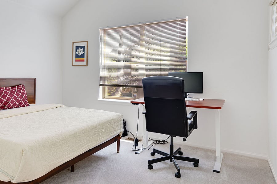 Bedroom with Queen bed and adjustable standing desk with external monitor. Blackout curtains can be added if desired. 