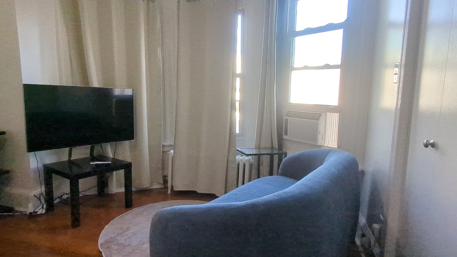 Front bedroom (Single Deluxe) private sitting area with loveseat sofa, TV and side table.