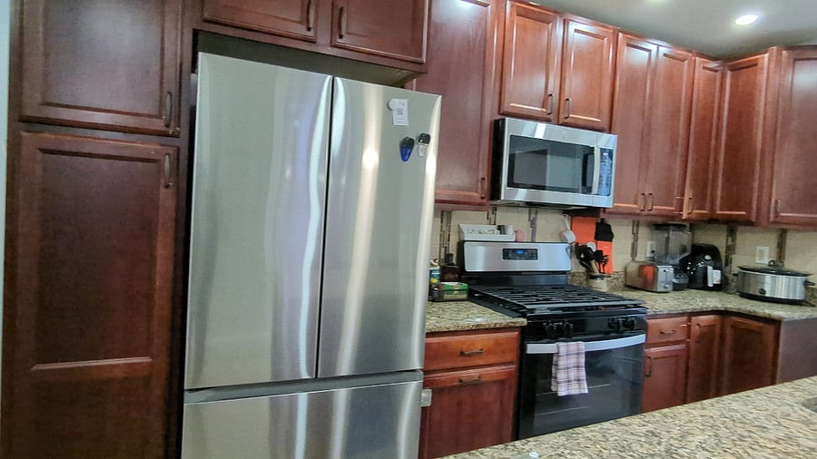 Beautiful cherry wood kitchen with island sink, brand new refrigerator, microwave and gas stove.