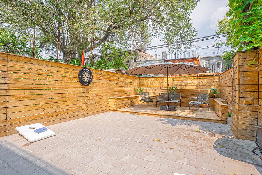 Fenced backyard with patio seating and games