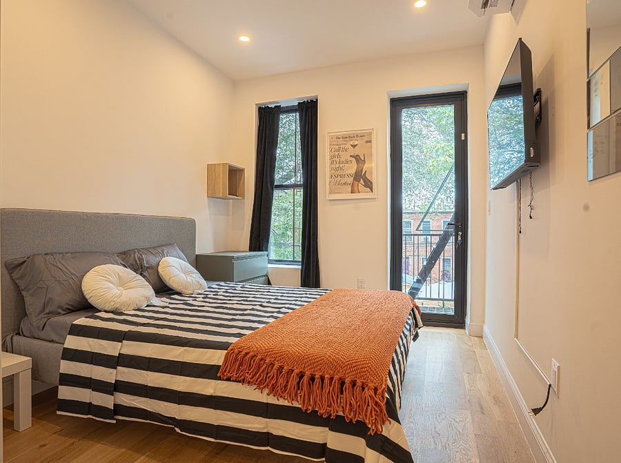 Bedroom with smart TV and private balcony access