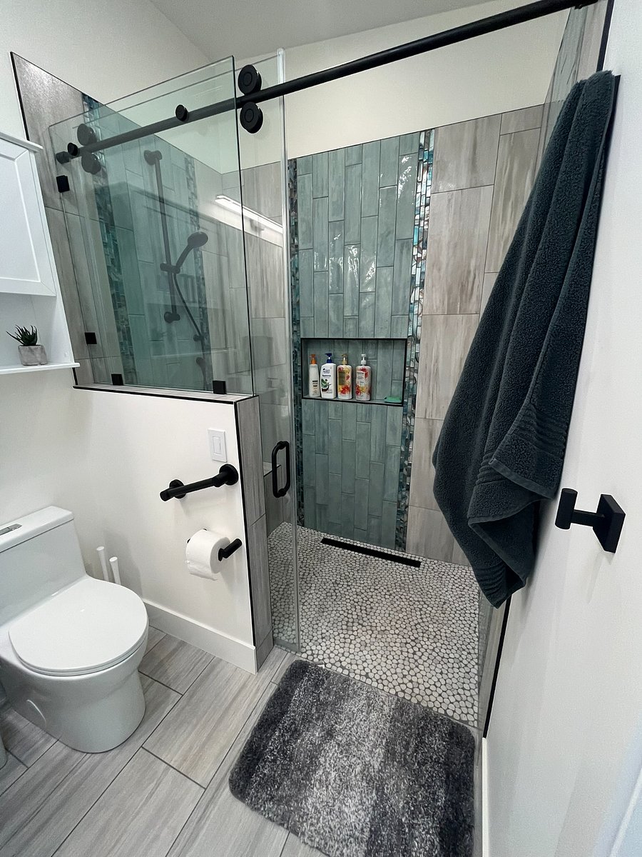 Large bathroom with solar tube and a bench in the shower.