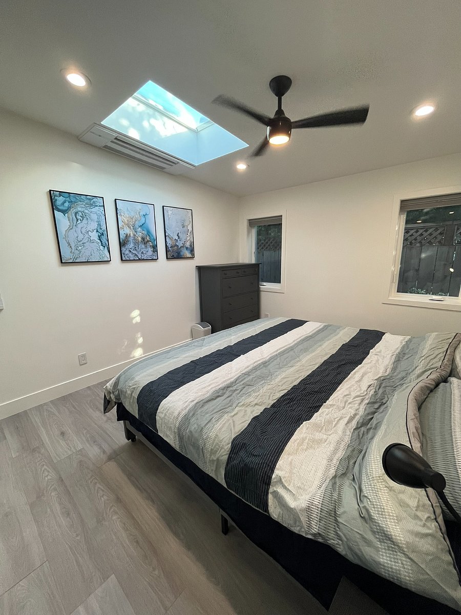 Primary bedroom with king bed, dresser, nightstands with reading lights and a huge closet. Also features a skylight, ceiling fan and individual heat / cooling control.