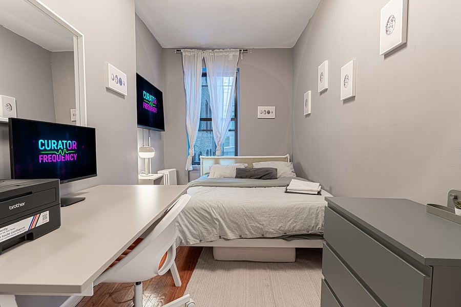 Sunlit bedroom with workspace, smart TV & cozy queen bed