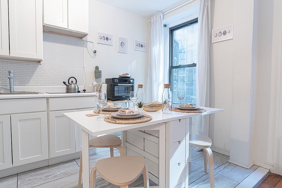 Chic white kitchen with dining table styled for four  heart of the home