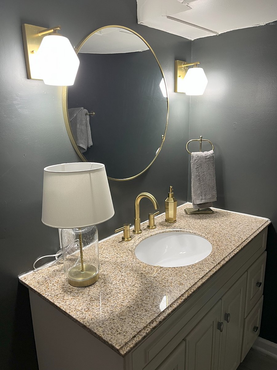 Elegant vanity with granite countertop, gold faucet, and stylish lightingyour own spa-inspired space to unwind.