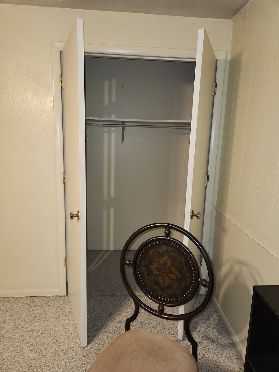Closet at back of living room, adjacent to kitchenette entrance