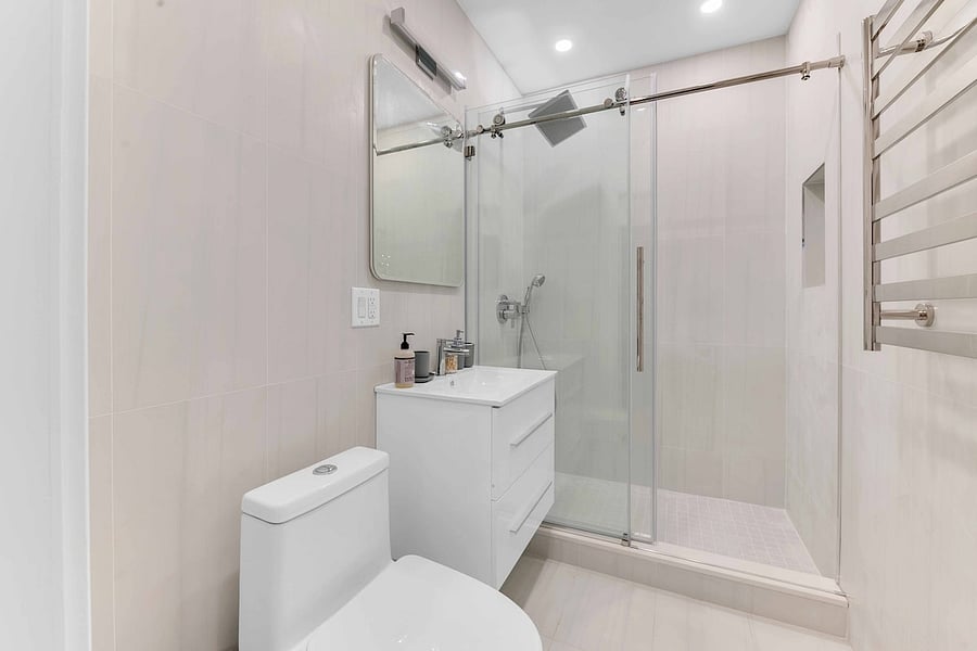 Modern bathroom with glass walk-in shower and floating vanity.