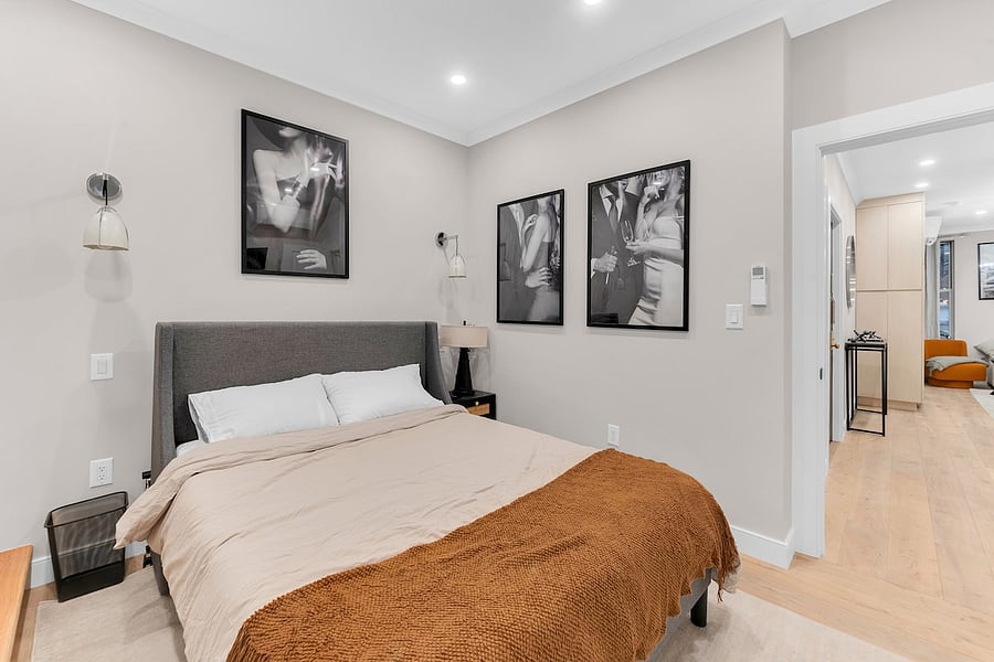 Third bedroom with plush bedding and curated art panels.