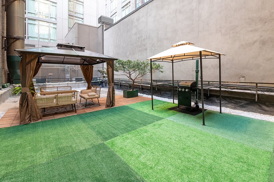 Sprawling private terrace with turf lawn and two pergolas  rare outdoor space in Manhattan.