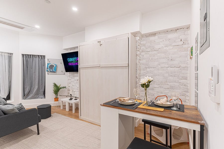 Sleek kitchen-and-dining nook with a wood counter set for two and full appliances  cook, eat and relax in this smart studio layout.