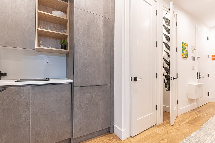 Modern kitchenette with grey cabinetry, cooktop and clean prep space  everything you need to cook between NYC adventures.