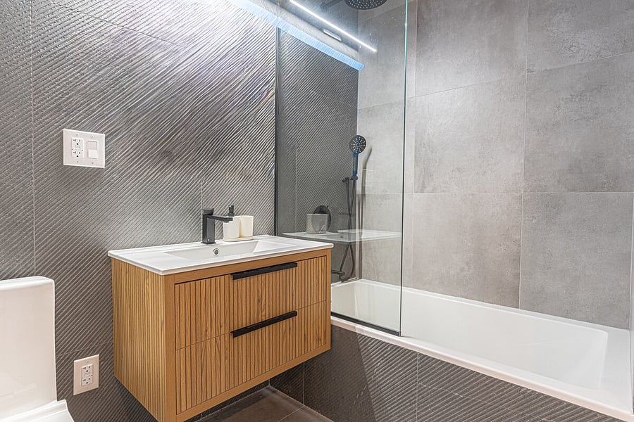 Clean, contemporary bathroom with a sleek wood vanity and fresh fixtures  spotless and ready for your stay.