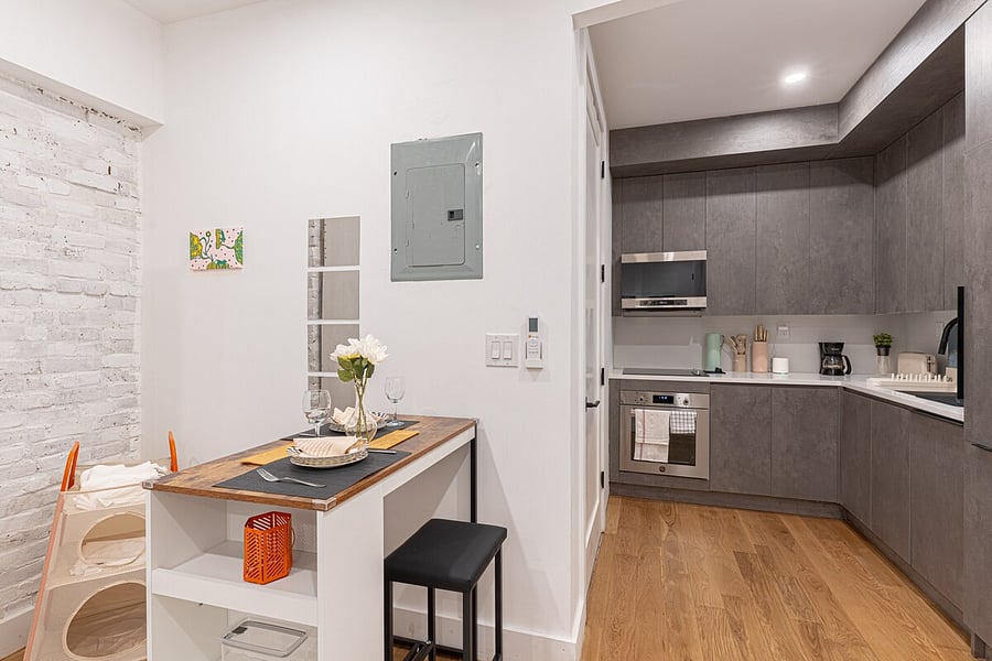 Open studio living and sleeping space flowing into a modern kitchen  a bright, efficient Brooklyn home base.