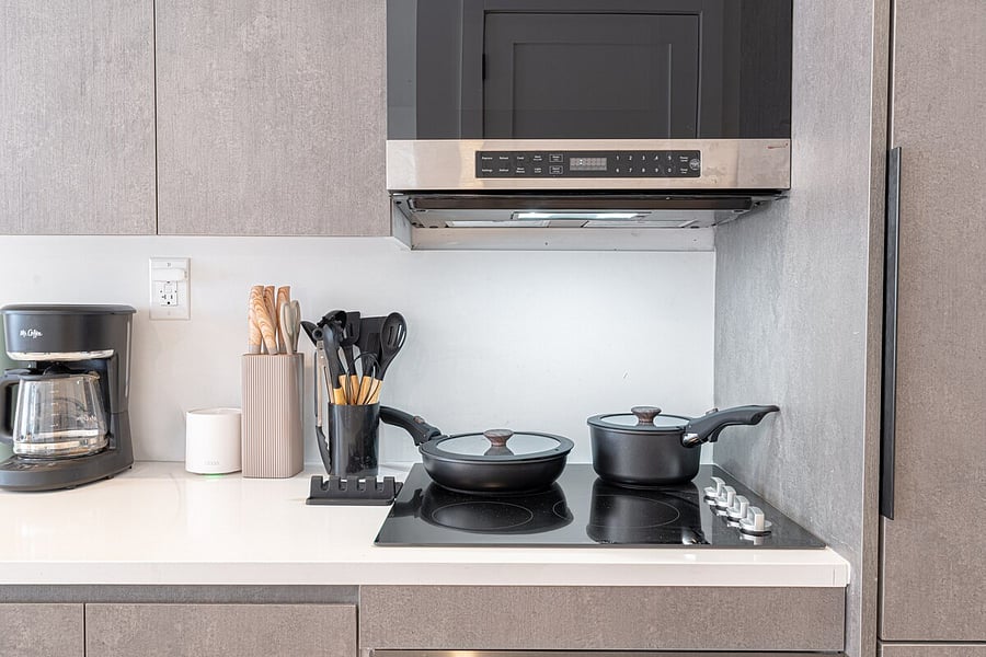 Cooktop stocked with pots, pans, and coffee maker  everything you need to whip up meals.