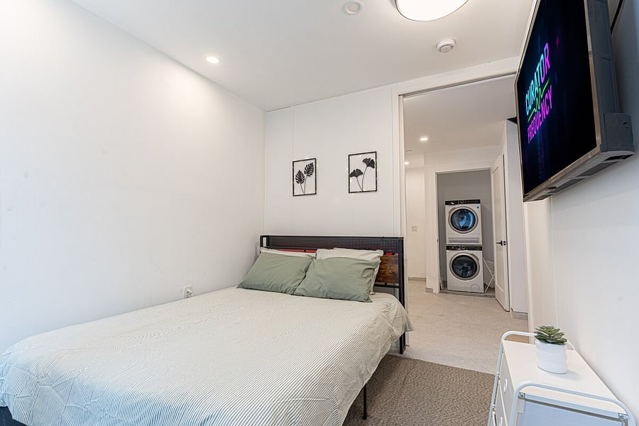 Comfortable bedroom with a smart TV and in-unit washer/dryer just steps away.