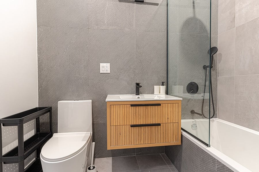 Spa-style renovated bathroom with a glass walk-in shower and rainfall fixtures.