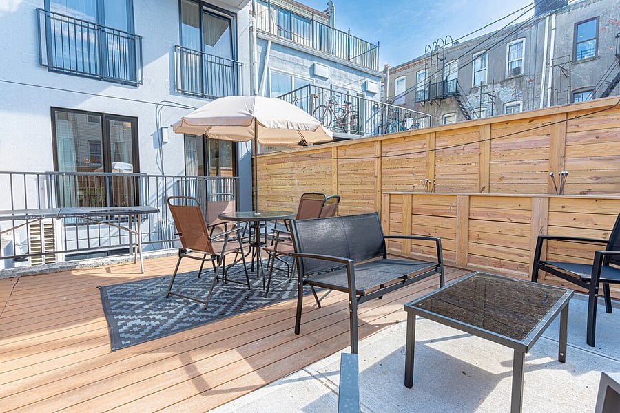 Sunny private deck with shaded dining and lounge zones  a rare Brooklyn outdoor escape.