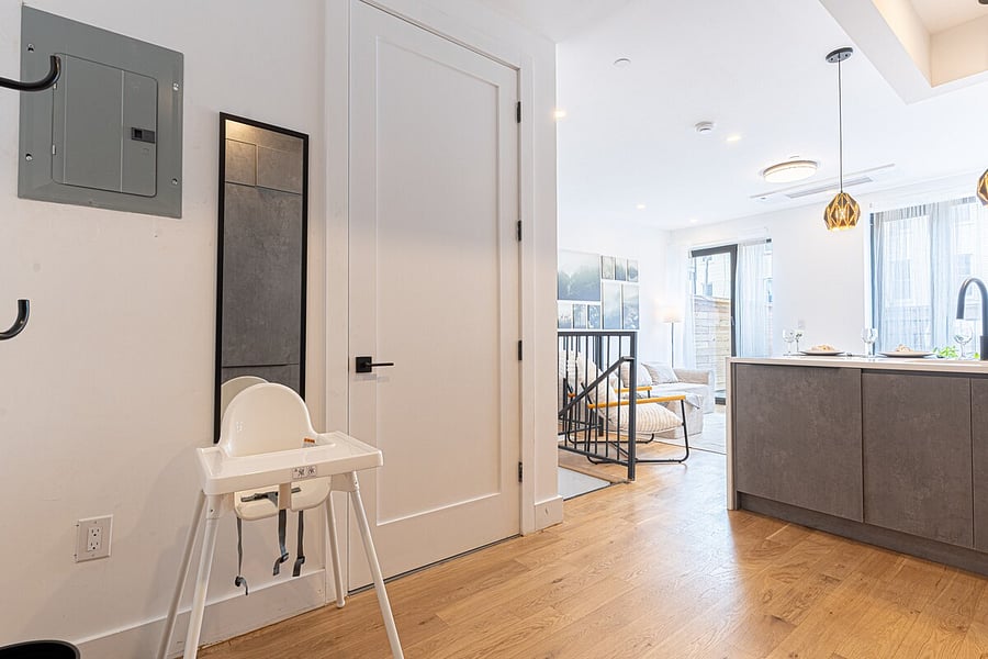 Practical entry with a mirror, coat rack, and high chair  easy drop-zone for bags.