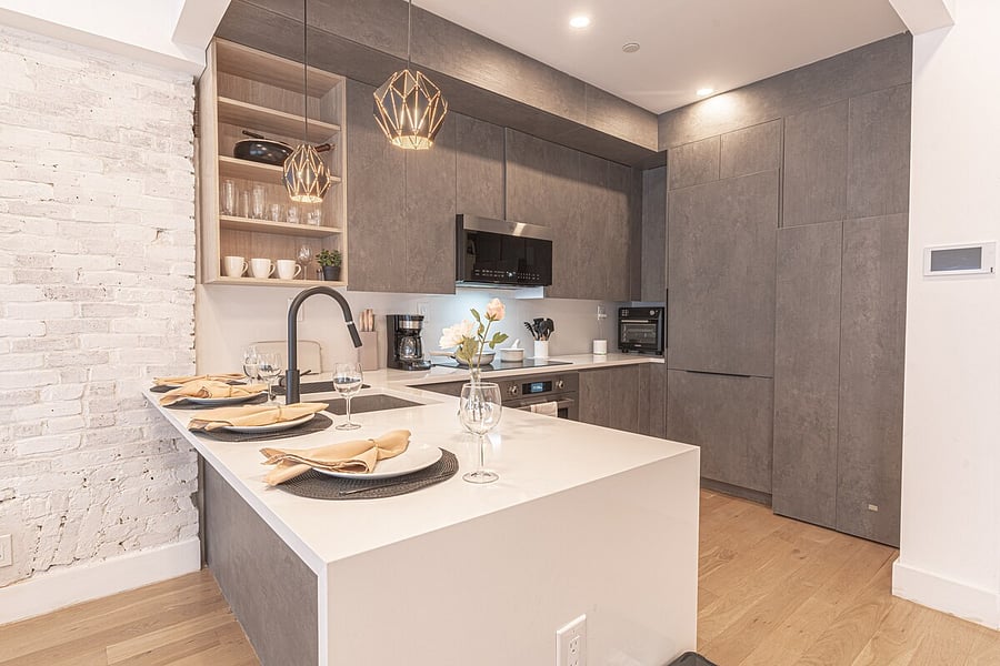 Modern full kitchen with a quartz island, sleek cabinetry and stainless appliances.