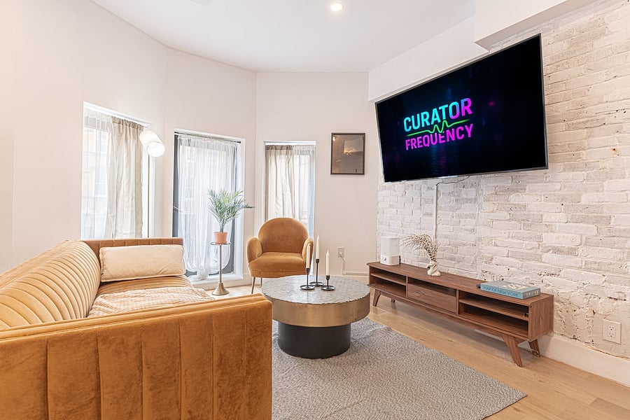 Inviting living room with plush seating, a statement stone wall and large windows.