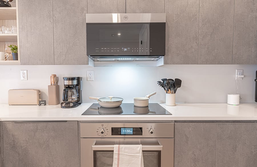 Sleek cooktop, oven and range hood with coffee maker and prep space  everything you need to cook.