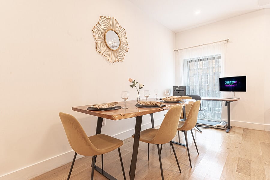 Dining table set for a meal with four soft velvet chairs  perfect for shared dinners.