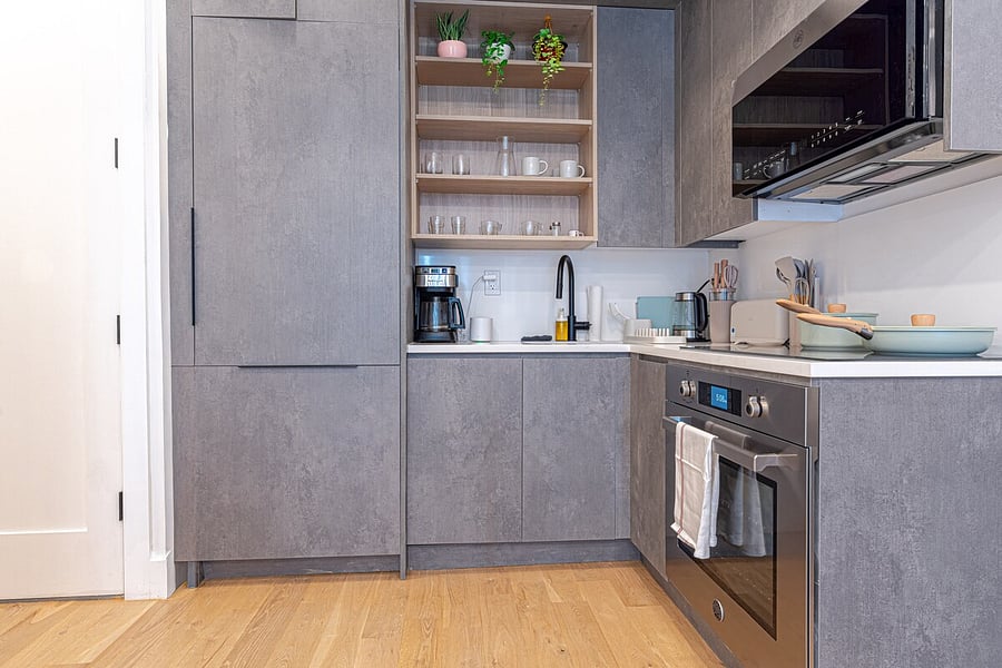 Sleek renovated kitchen with ample cabinetry and full-size fridge.
