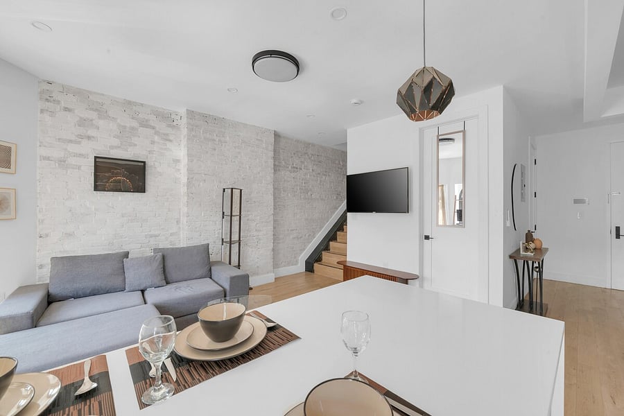 Comfortable living and dining space with a plush sofa and smart TV.