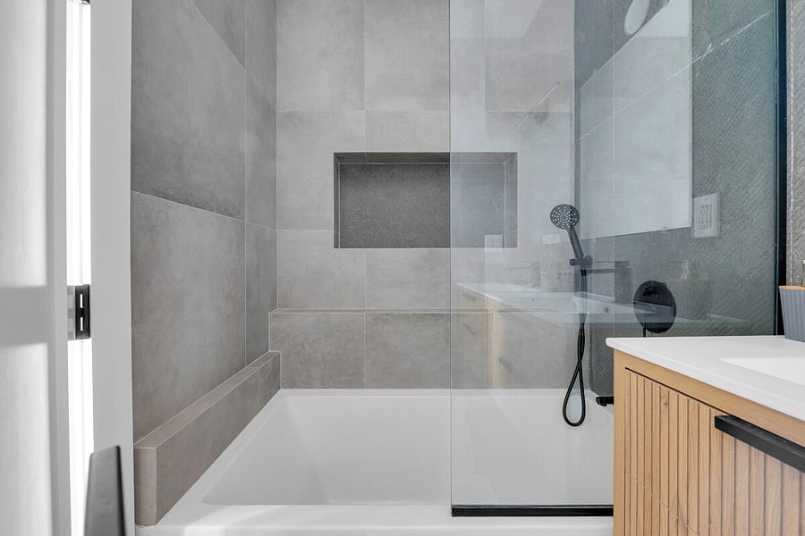 Spotless walk-in glass shower with floor-to-ceiling tile.