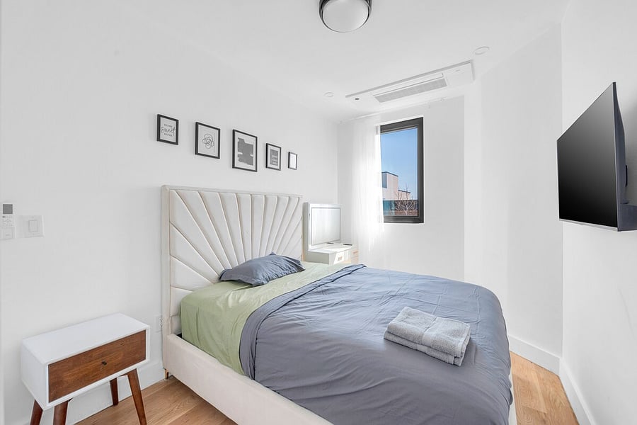 Restful bedroom with an upholstered headboard and soft linens.