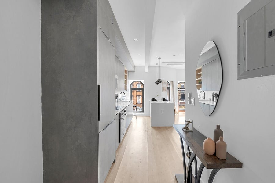 Bright living room with exposed brick, arched windows and cozy seating.