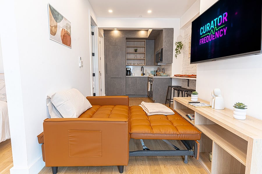 Comfortable bedroom with a mounted TV and plush bedding  wind down in comfort.