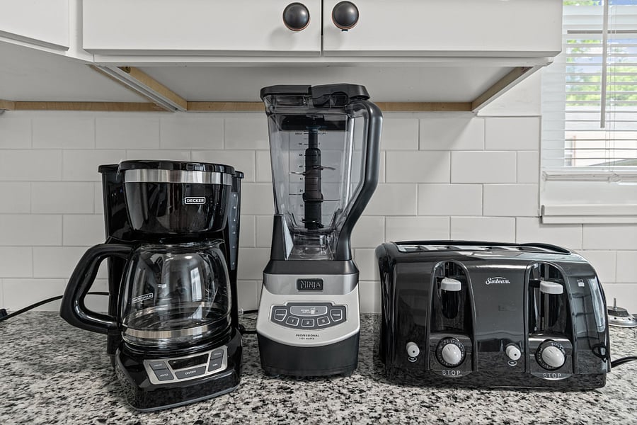 Kitchen detail. Stocked with the small appliances you actually use, coffee maker, blender, and toaster, plus full cookware and dishes.