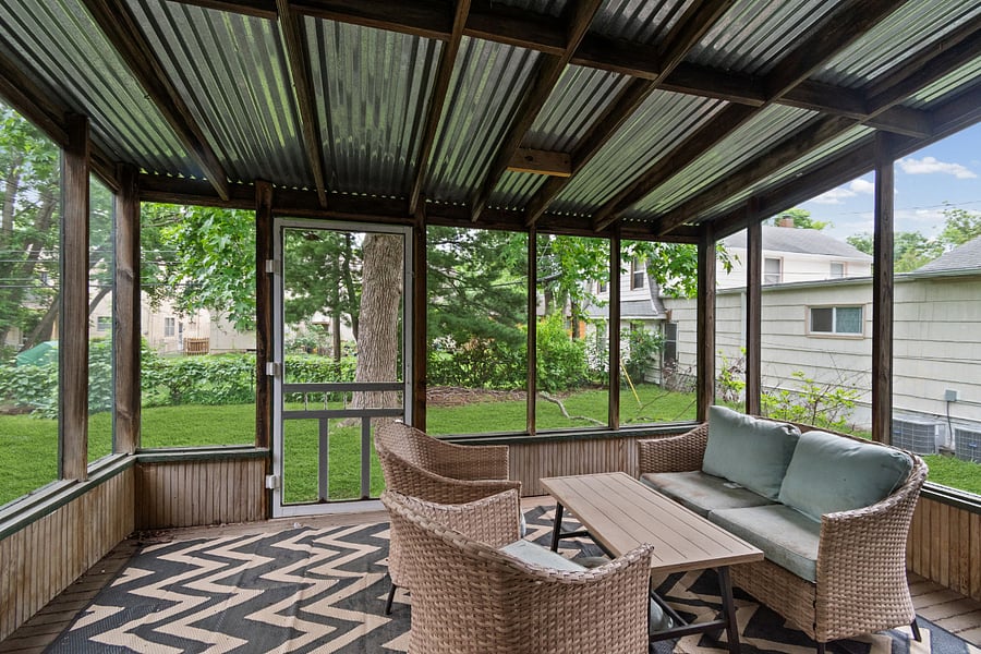 Screened porch. The feature guests talk about most. A fully enclosed porch with wicker lounge seating and green tree views, a private outdoor living room that works in every season. Morning coffee here is not optional.