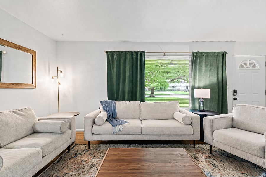 Living room. Your daily retreat, built for long stays. A 65 inch Amazon Fire 4K UHD smart TV anchors the room, with a designer blue accent wall, comfortable seating, and big windows that keep the space bright. Settle in for game day, a quiet evening, or a movie after exploring Waldo.