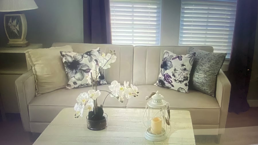 'Versatile third bedroom featuring a queen-size sleeper sofa, dedicated workspace, table, coastal accent chair, and beach inspired decor."