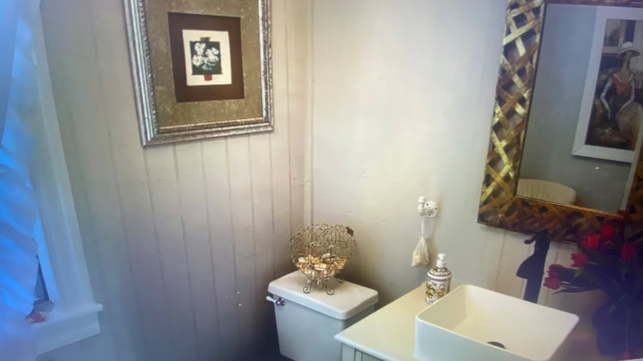 "Beautifully designed half bath featuring elegant coastal decor, conveniently located next to the laundry room and easy access to the spacious outdoor deck."