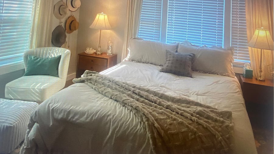 "Relaxing master suite with a king size bed, coastal-inspired decor, and a private suite bathroomBright and  with a walk-in shower."