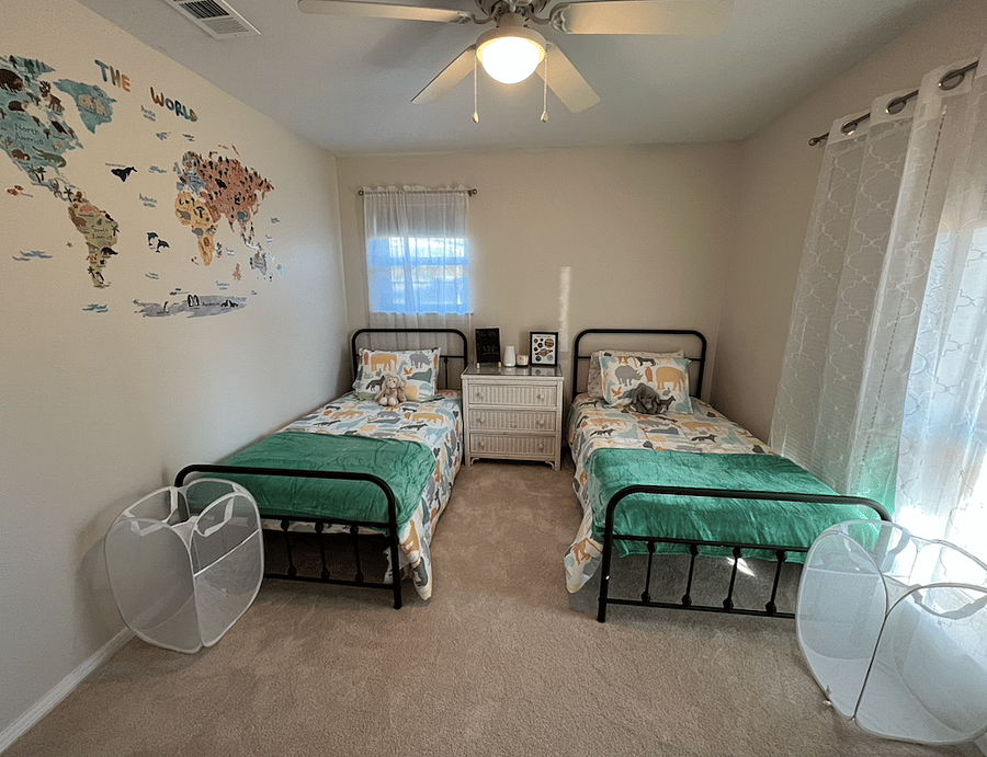 Twin bedroom with blackout shade and blackout curtains.