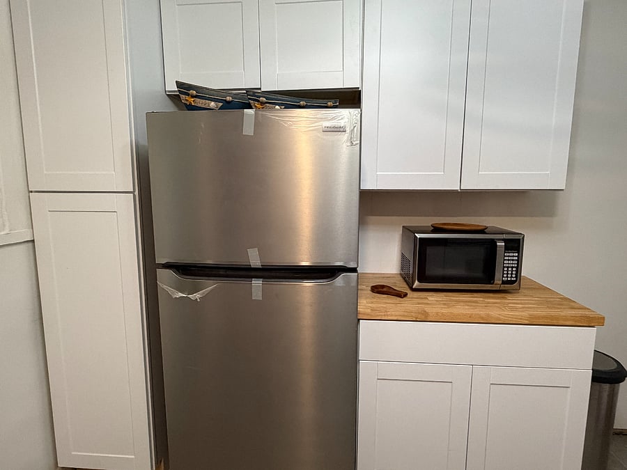 Kitchen complete with refrigerator, dishwasher, coffee maker, toaster oven/air fryer combo, and microwave.